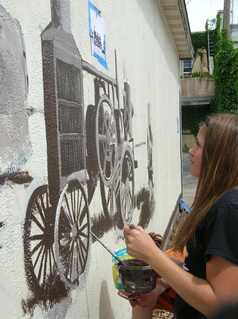CFHS senior, Molly Thomforde, prepares to touch up the Harvest Mural that she and four other students painted under the guidance of muralist Steve Delaitsch in downtown Cannon Falls