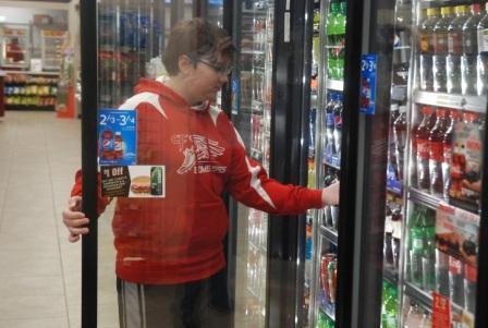 Ben Siebenaler reaches for a drink in the cooler at the new Caseys store