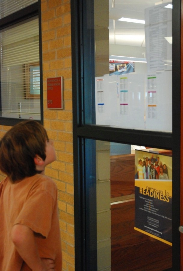 A cast member scans the Wizard of Oz cast list posted on the office window