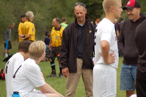 Coach Rueger chats with team members on the sideline
