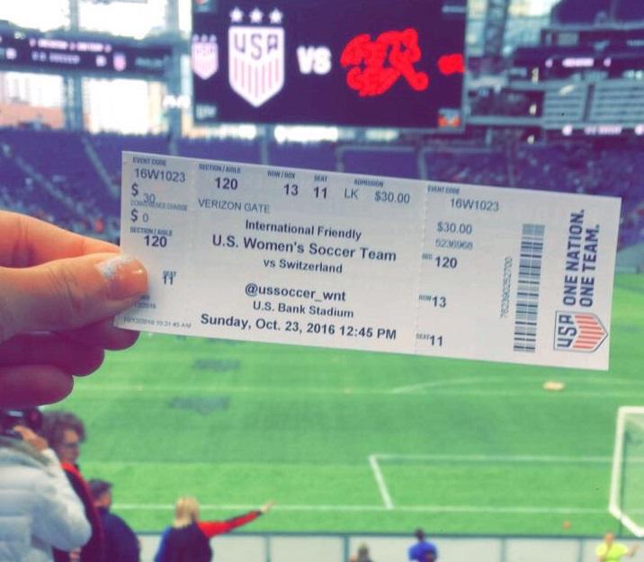 A Bomber soccer team member holds up a ticket to the game