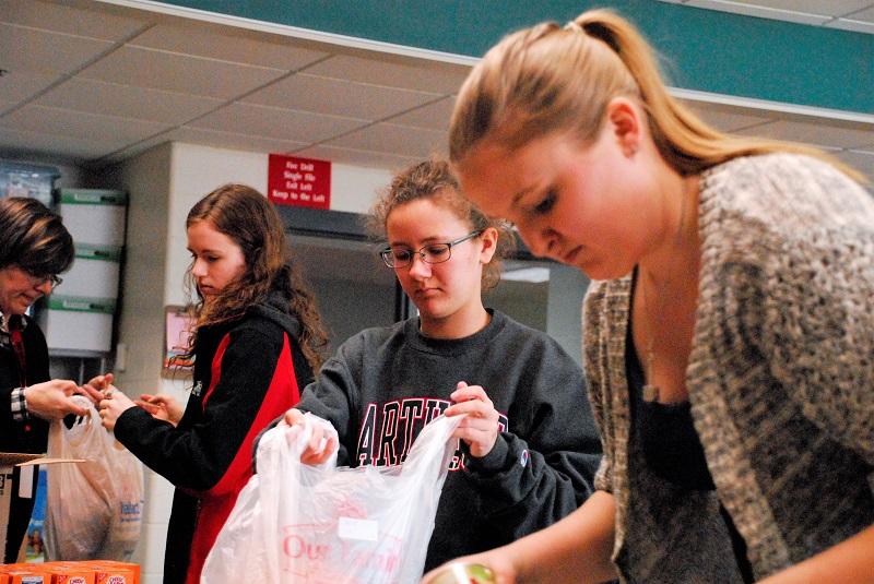 NHS students pack backpacks with food