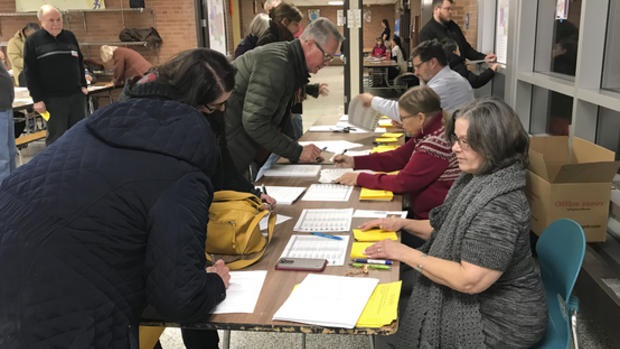 Volunteers help community members register at the DFL caucus in Senate District 54. 