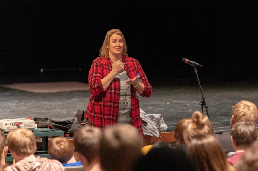 Laura Thomas addresses the junior class in the auditorium.