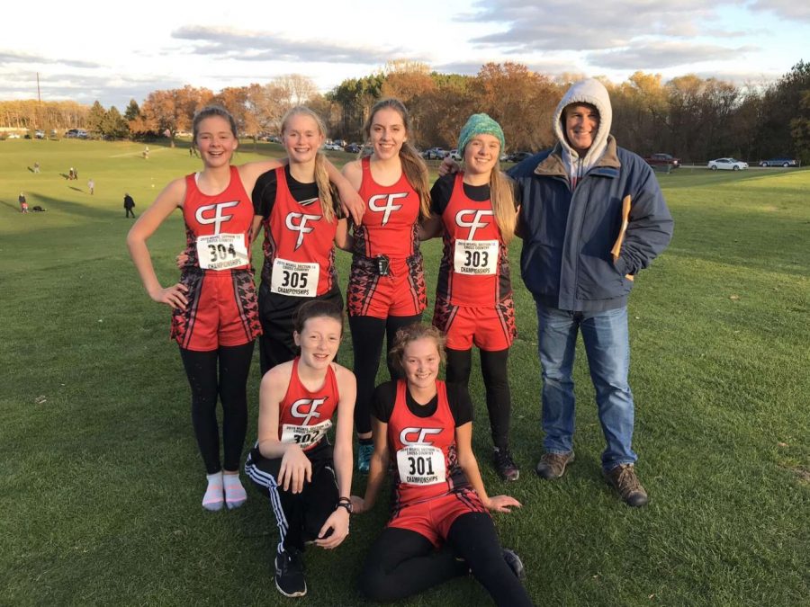 Cross Country runners pose for a photo with coach Ben Schopp after sections.