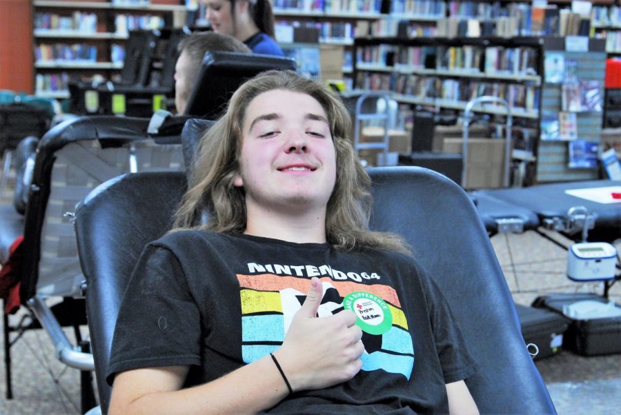 Senior Preston Heckmann gives a thumbs up for his first experience participating in a blood drive.