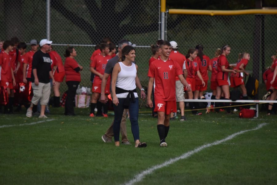 Senior soccer player, Michael Fimmen, walks with his mom for senior night.
