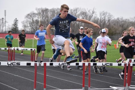Adam Korkowski leaps over the hurdle during a group run at track practice.
