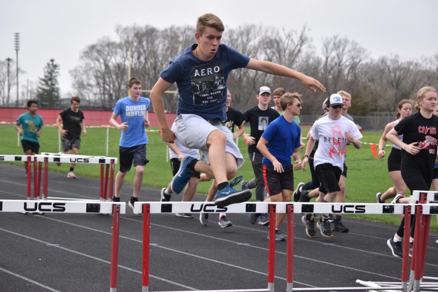Adam+Korkowski+leaps+over+the+hurdle+during+a+group+run+at+track+practice.