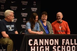 With her parents and coach by her side, Abby Breuer signs a softball commitment. 
