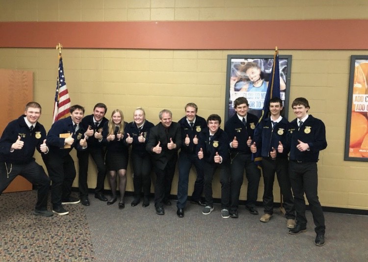 An excited team of FFA members smile for the camera.