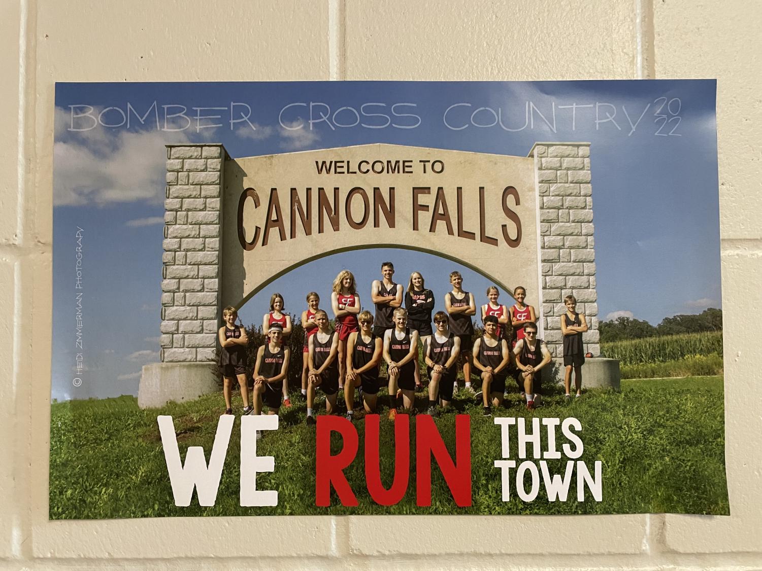 The cross country team poses in front of the Cannon Falls welcome sign