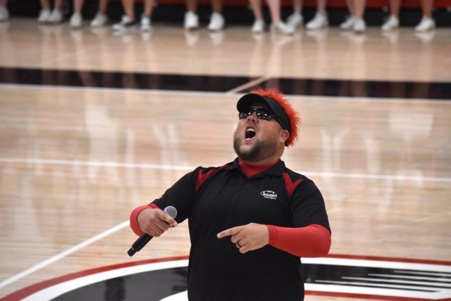 Teacher, Tyler Quinlan, hypes up the students for the football game. 