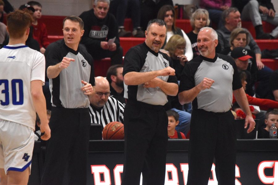 Referees discuss among each other before a Bomber basketball game.