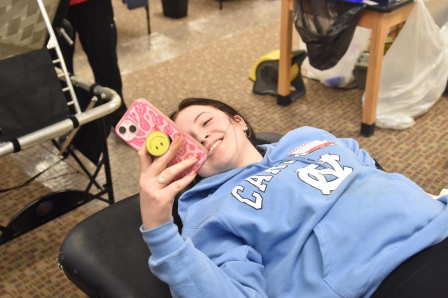 Elayna Sherer relaxes by going on her phone while giving blood. 