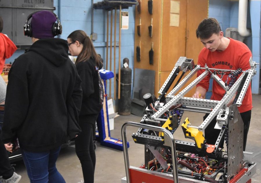 Brighton Lochner mounts the robot so other team members can perform their tasks.