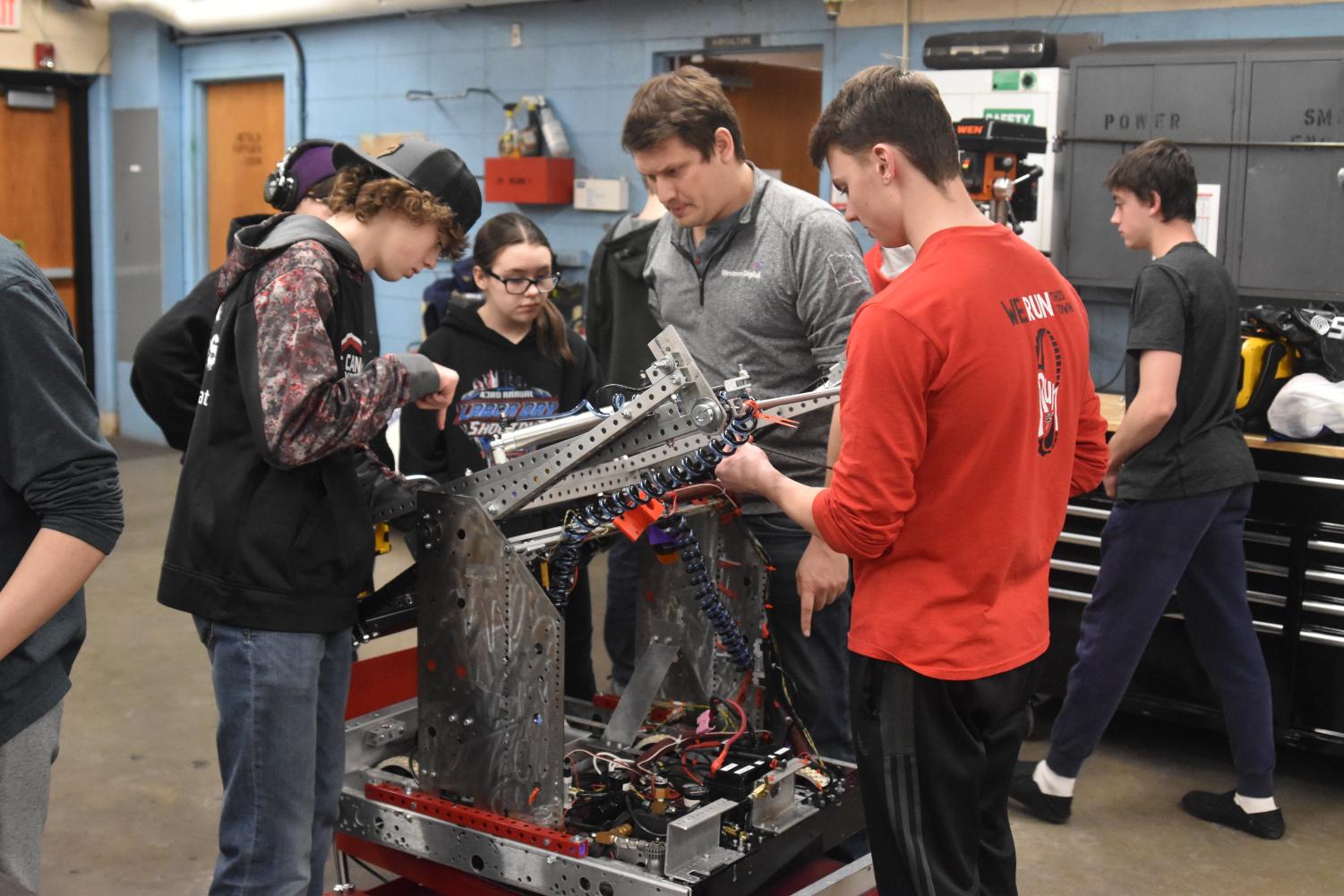 CFHS Bomb Botz members gather around the robot to add the finishing touches to their Robot before heading to competition in Duluth. 