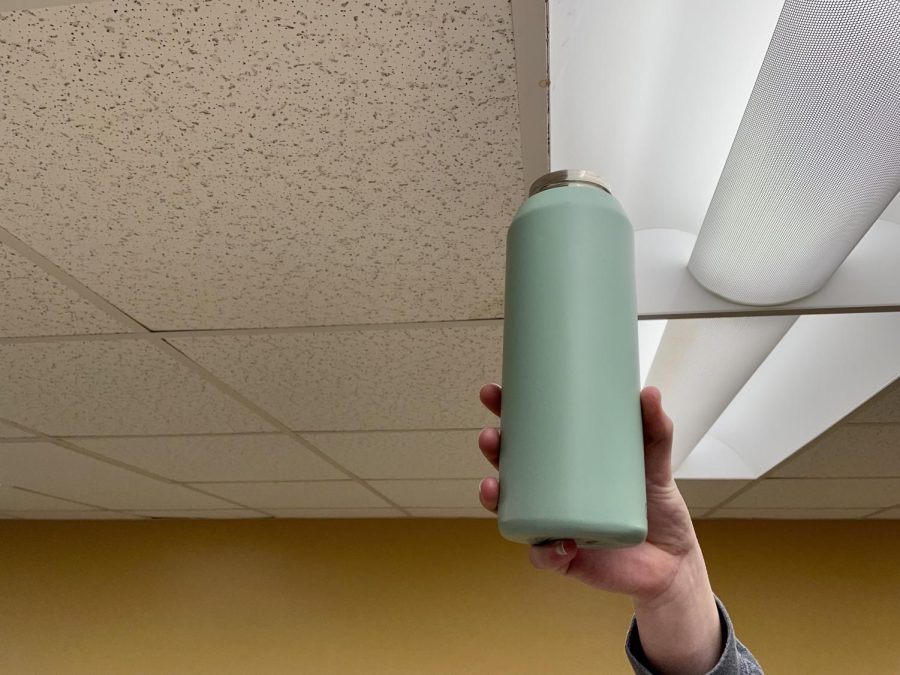 An individual collects the precious water from the crack in the ceiling tile. 