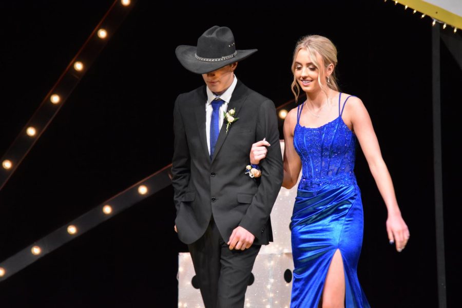 Kalahan Anderson and Maddie Becker walk down the stage during the Grand March event. 