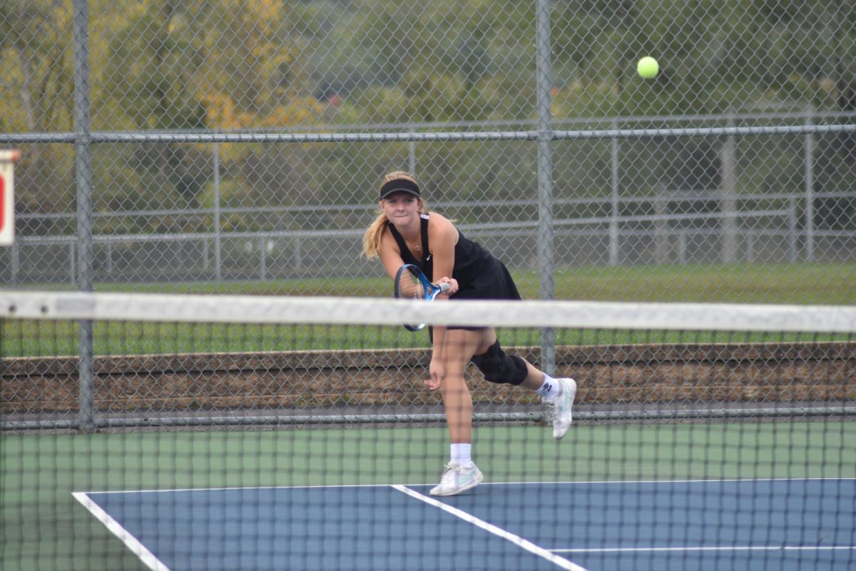 Julia Reed hits the ball over the net to her opponent.