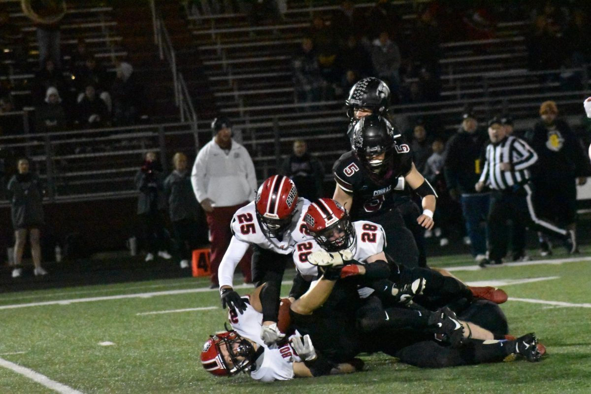 The Bombers pile on their opponents to pry the ball away from their hands.