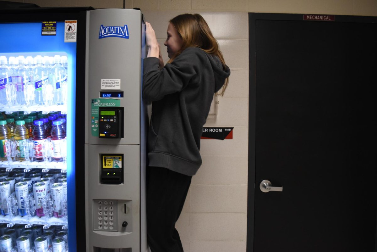 Anya struggles to know down the vending machine.