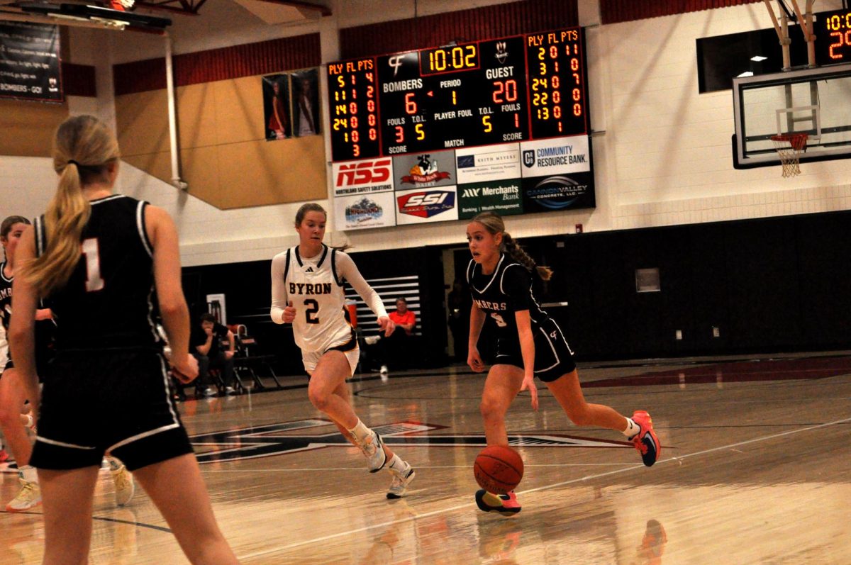 The girls basketball team dribbles down the court for the point.