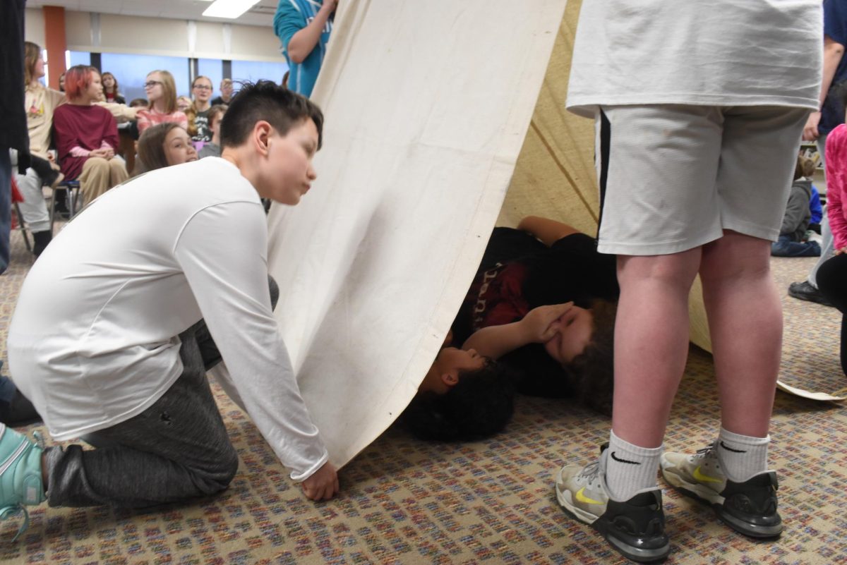 Brezlun Qualey learns to build a tent just like the good old days.