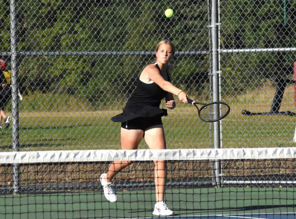 Cameron Anderson hits the tennis ball with a good swing.