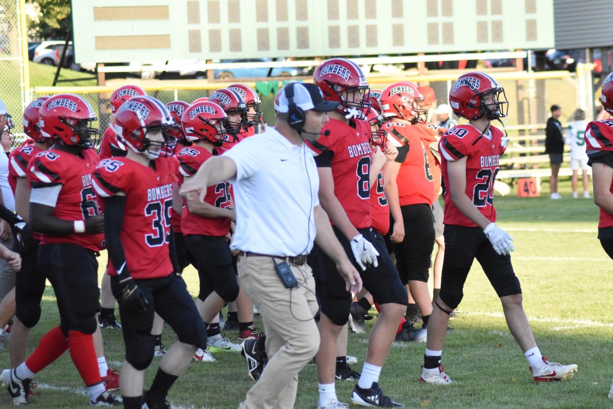 head coach Dan Myers leads his team on the field  