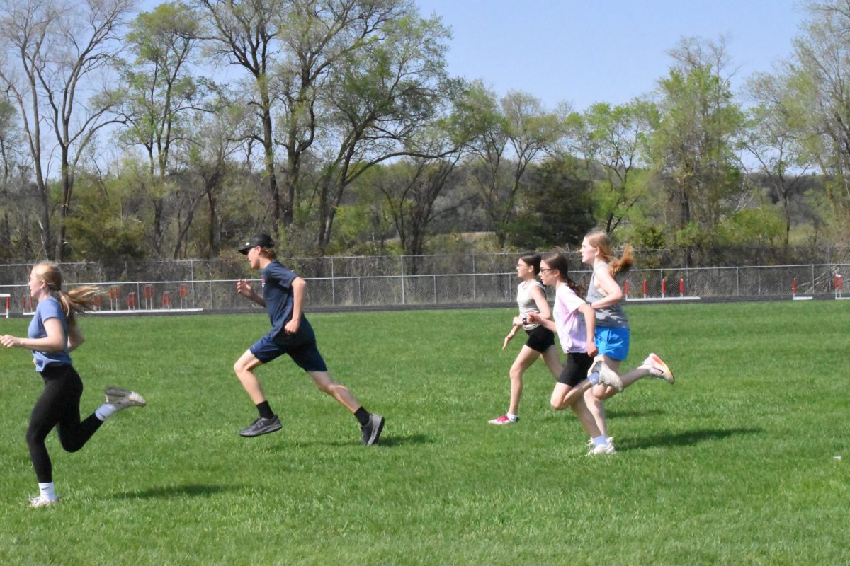 Jr. High Track and Field run their buildups on the grass.