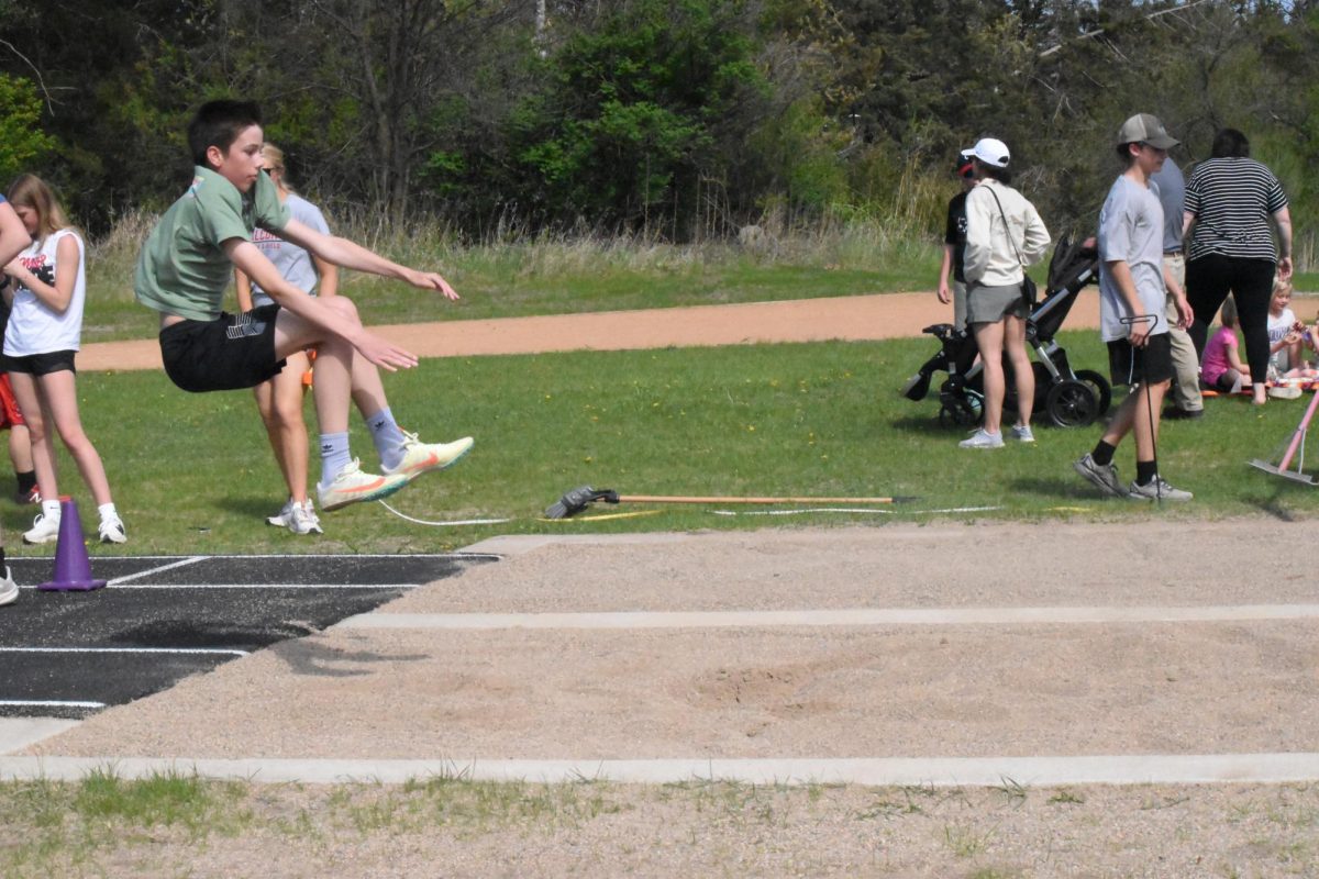 Logan Theil practices his knee drive for long jump.