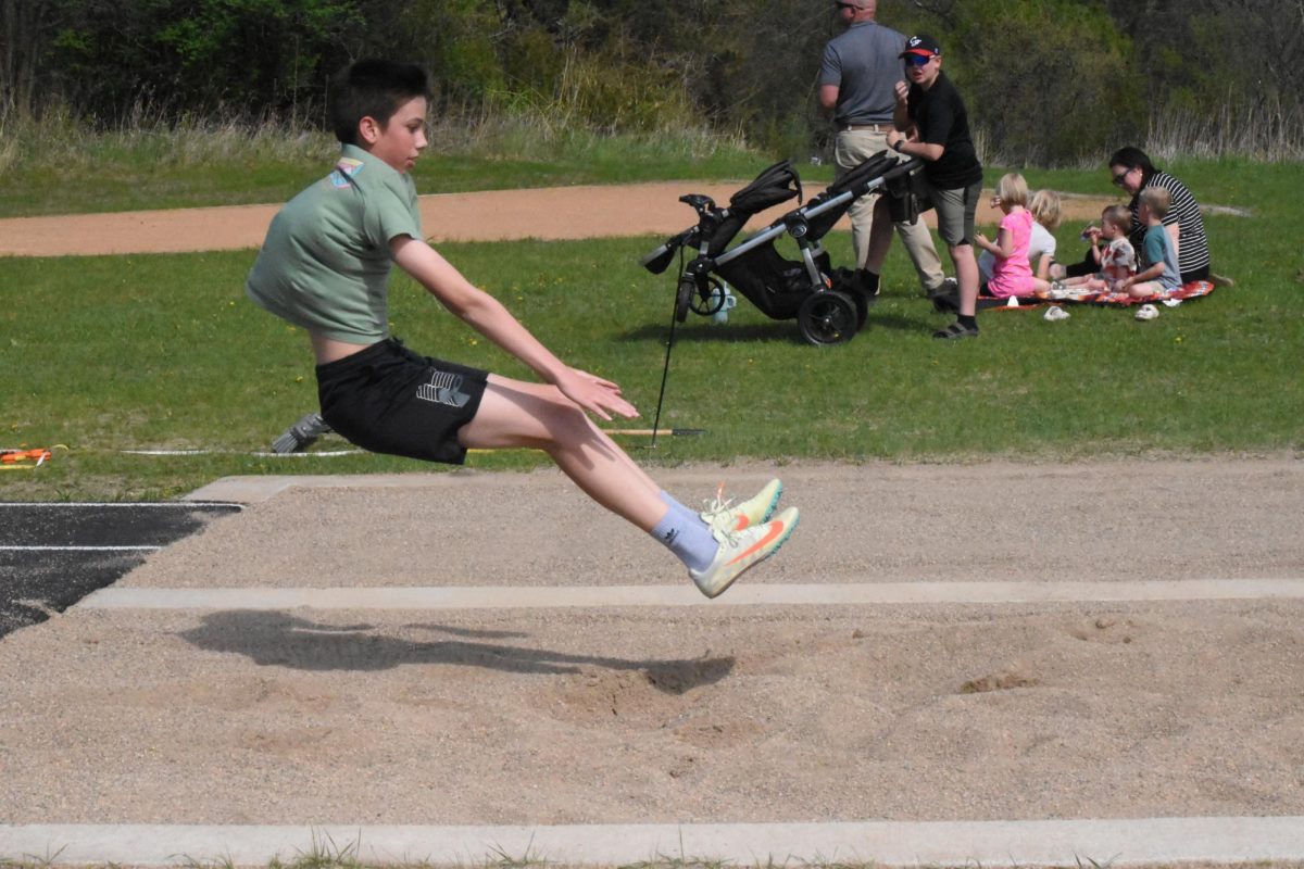Logan Theil practices his arm rotation for the long jump