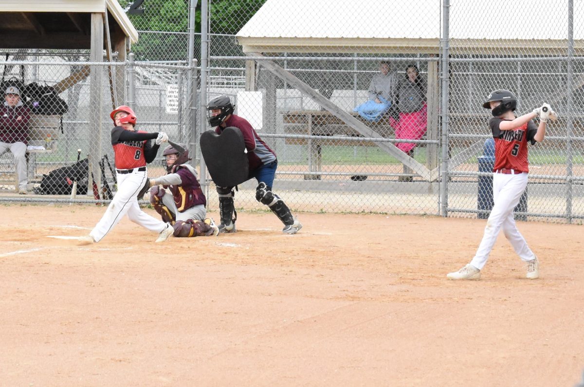 Slade Schramske takes a big cut while Kolton Miller waits on deck