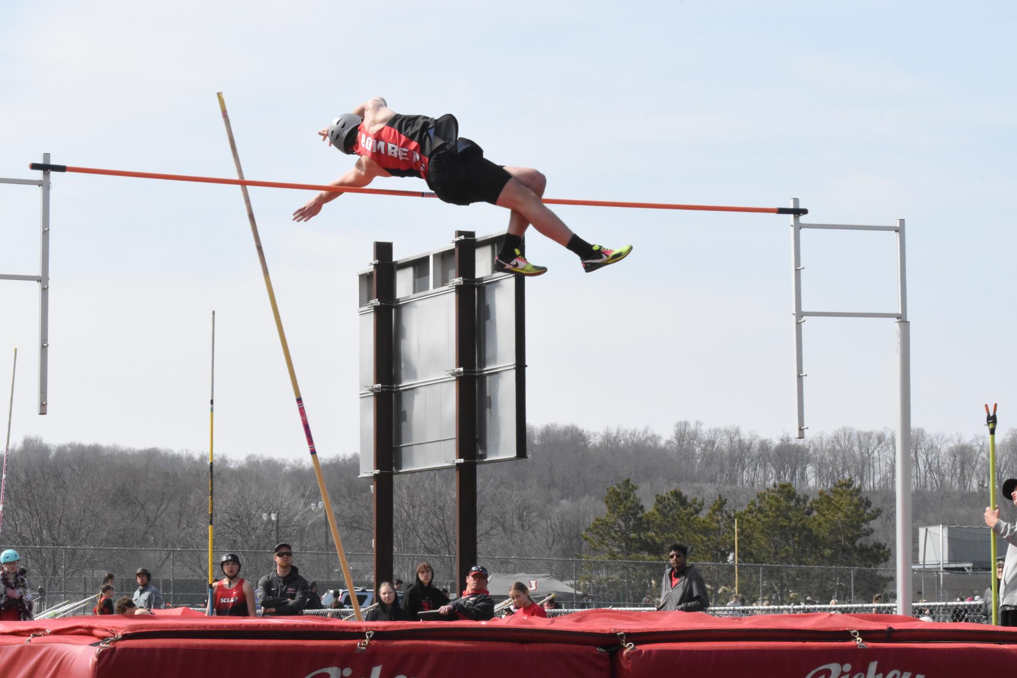 Junior trackster Graham Bray completes a pole vault.