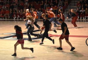 Middle schoolers compete against high schoolers in a game of red light green light during the homecoming pep fest