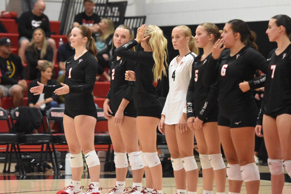 The varsity volleyball squad waits for the match to begin.