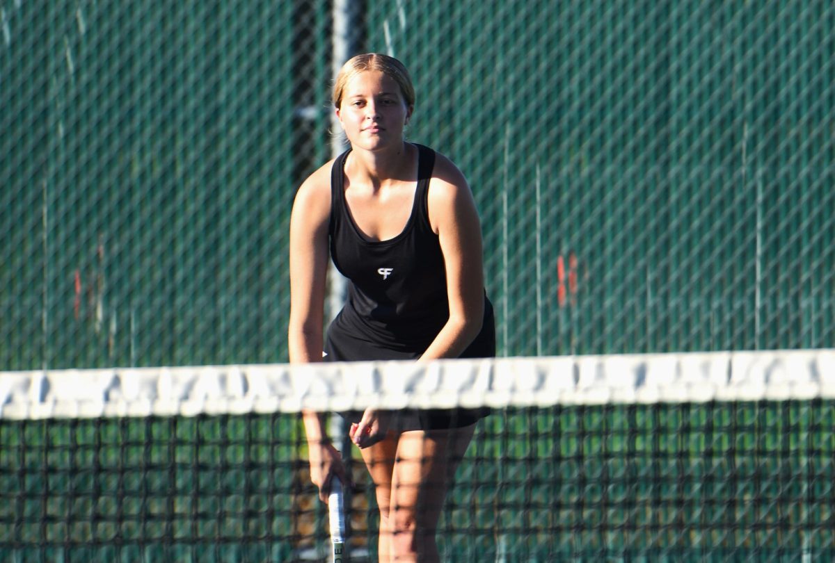 Cameron Anderson waits for her opponent to serve during her doubles match.