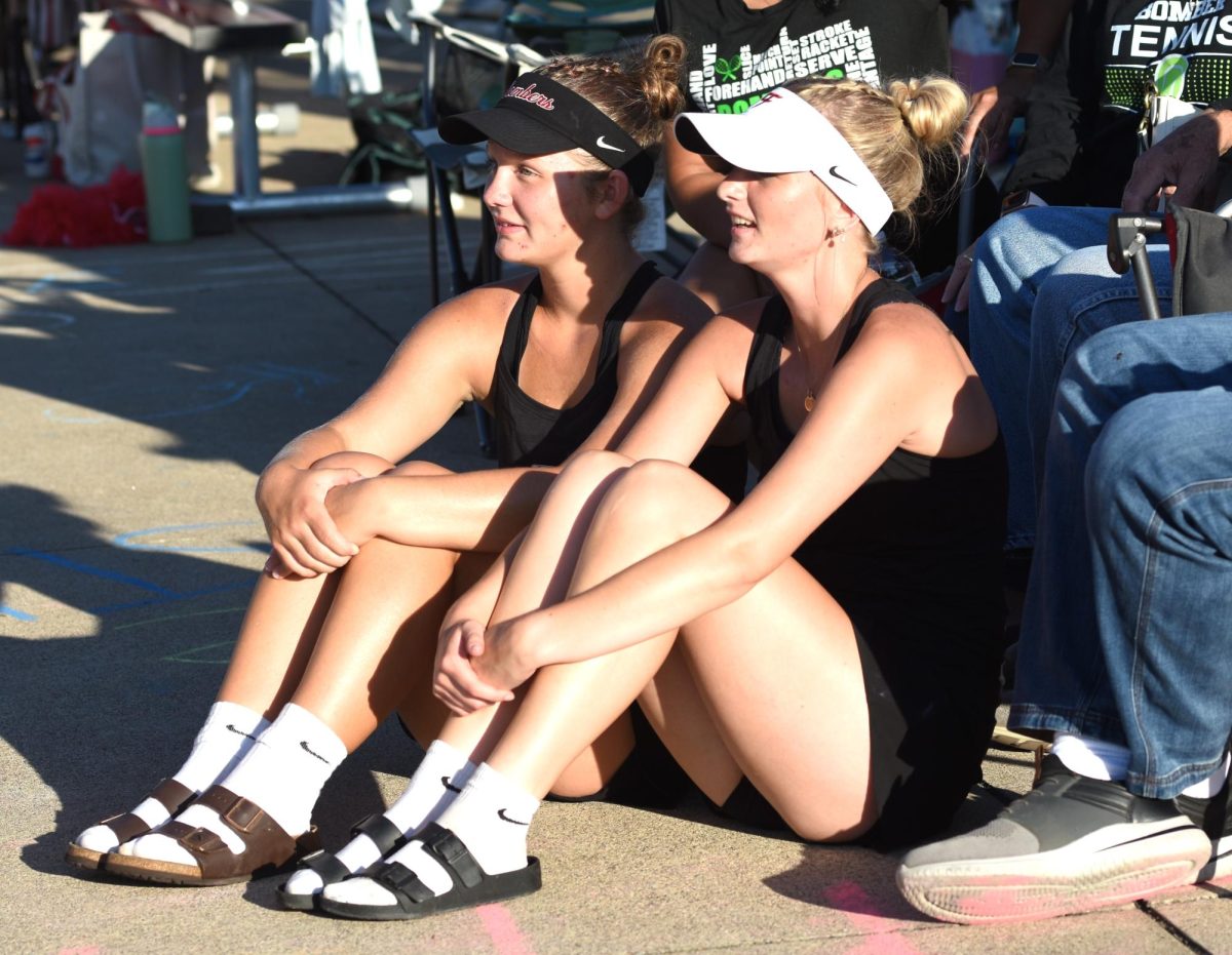 Captains, Josie Sjoquist and Sophia Nerison, sit and watch their teammates play.