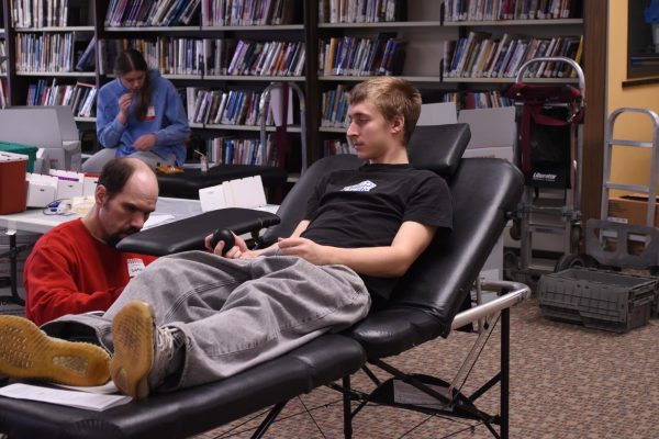 Axel Rapp prepares to donate blood by resting, as the phlebotomist sets up