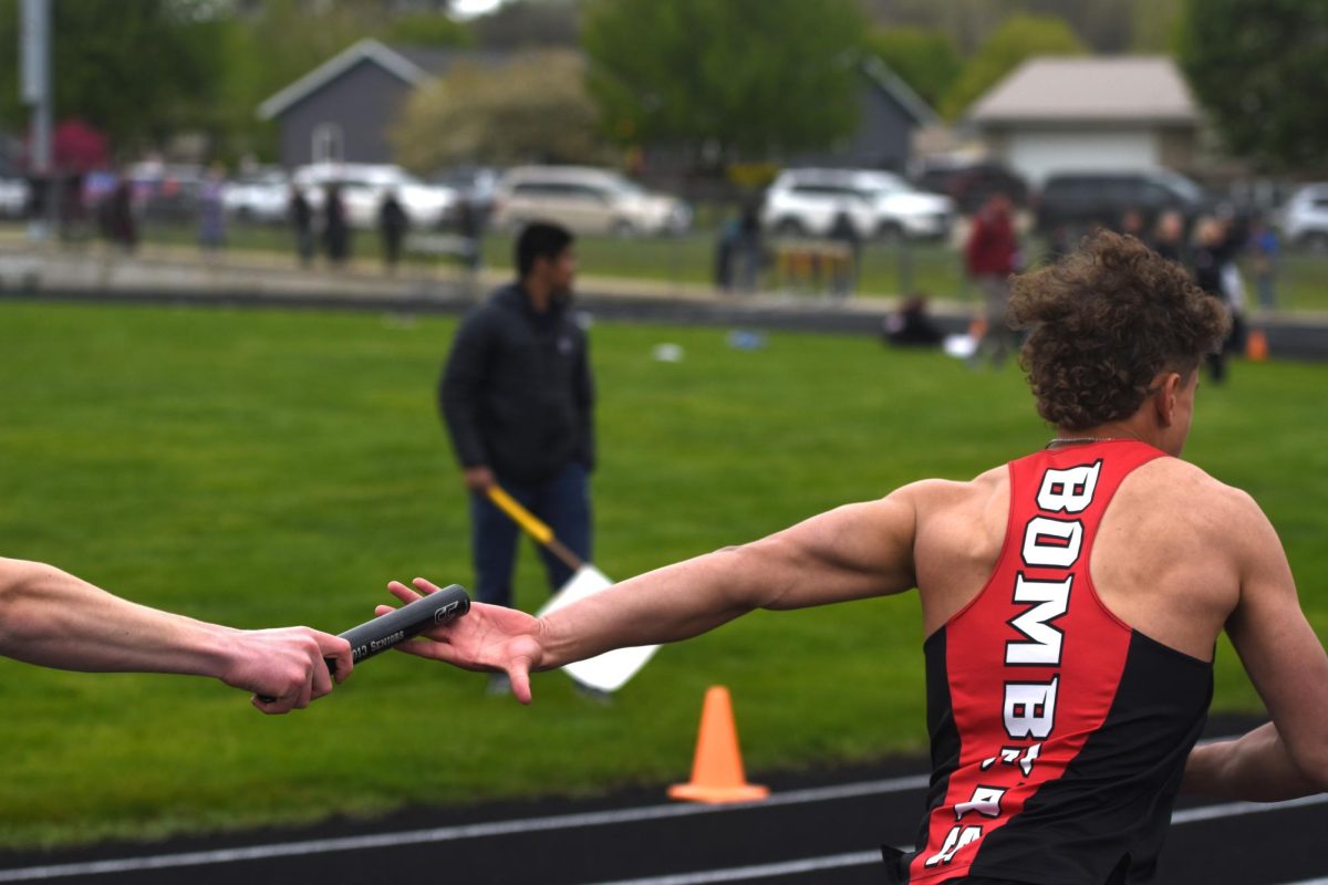 Caelan Heinlein (left) hands the baton to Dylan Menge (right) during the boys' 4x400 relay race at the True Team meet on May 5.